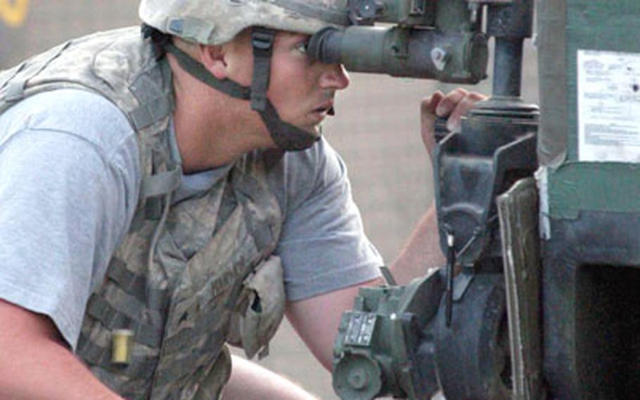 Sgt. Nicholas Harmon peers through the gunner sight of gun number one as the soldiers prepare to batter anti-coalition positions.