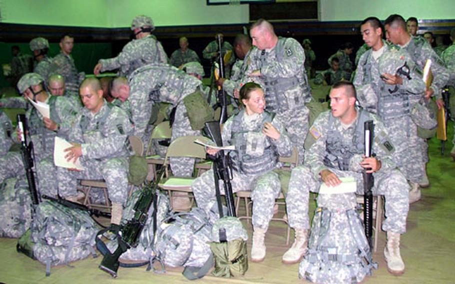 Soldiers of the 1st Battalion, 7th Air Defense Artillery take their seats before an in-processing session. Some 170 battalion soldiers arrived Wednesday and two more flights are to arrive in coming weeks.