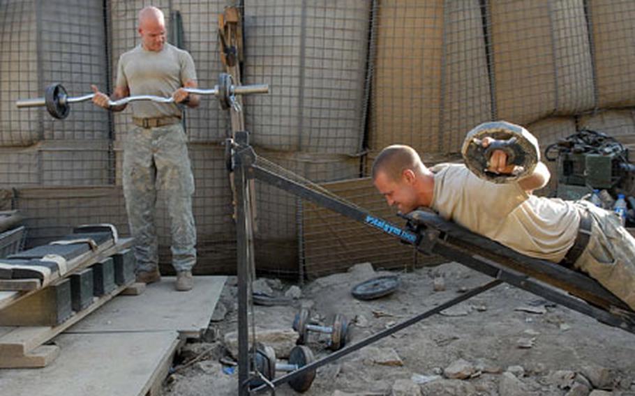 Specialists Paul Doty, left, and Justin McElroy, both of 3rd Platoon, Company C, 1st Battalion, 32nd Infantry Regiment, 10th Mountain Division get an evening workout at Fire Base Florida, in the Pech valley in eastern Afghanistan.