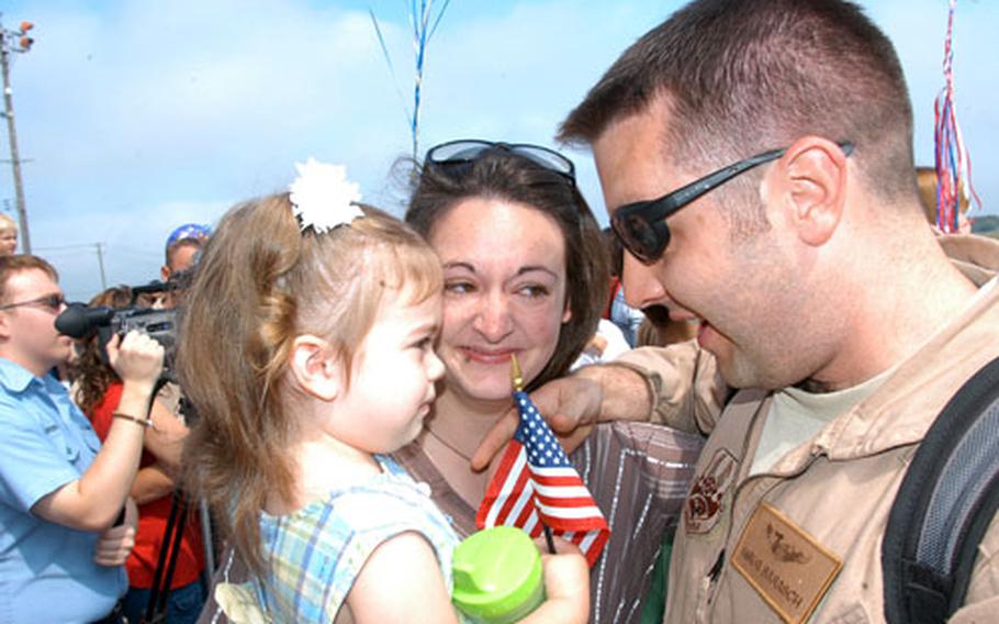 Capt. Greg Barasch of the 14th Fighter Squadron greets Allie, 2, and his wife, Karen, after returning to Misawa Air Base, Japan, on Saturday from a five-month deployment to Iraq. Barasch was among 300 returning airmen.