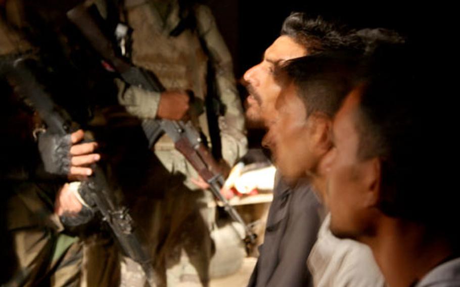 U.S. soldiers with the 1-12th Combined Arms Battalion and Iraqi troops question several men during a midnight raid on the village of Nahir Shallub.