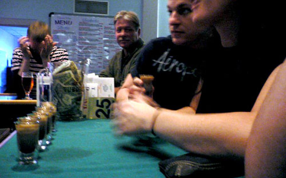 Patrons sit at a bar lined with shots at the Top of the World club in Thule Air Base, Greenland.