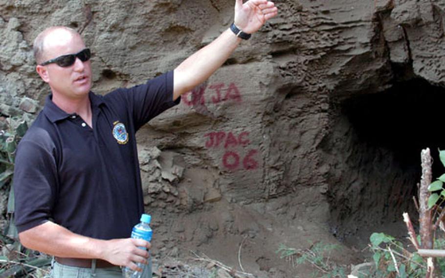 Maj. Sean Stinchion, a team leader with the Joint POW/MIA Accounting Command, describes the layout of an area of newly discovered caves found during a JPAC site investigation on Iwo Jima.