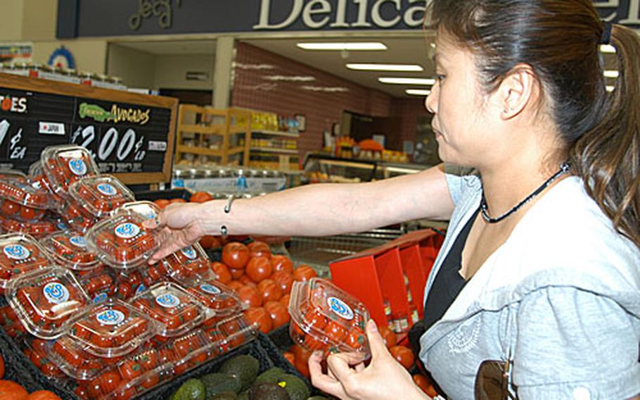 Jiyoung Wang, a Navy spouse at Misawa Air Base, Japan, shops for cherry tomatoes at Misawa’s commissary. While she said she prefers shopping for fruit and vegetables off base, where she thinks produce is fresher, she shops at the commissary for convenience.