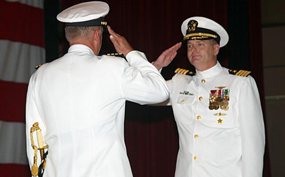 Capt. Kenneth Freeman, outgoing commander, Naval Base Guam (back to camera) salutes Capt. Scott Galbreaith, commander, Naval Base Guam, during the change of command ceremony.