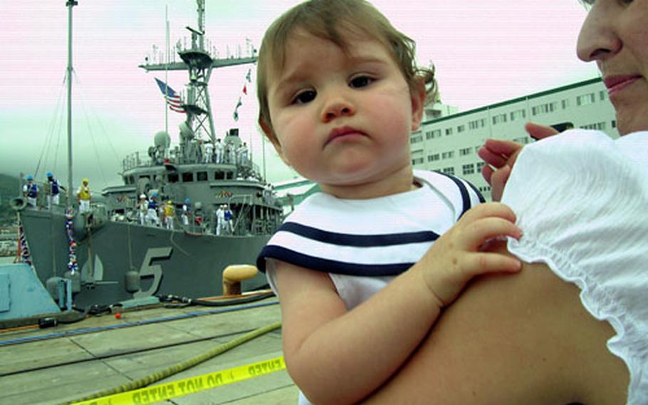 Sofia Summerhill&#39;s dad was almost home as the USS Guardian tied up at Sasebo Naval Base&#39;s India Pier. Her mother, Yvonne, is holding the 11-month-old. Sofia had no interest in wearing her sailor hat.