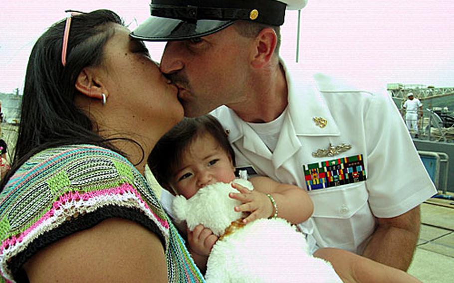 Jury Venczel, left, bought five tickets to "first kiss" raffle so her husband, Senior Chief Petty Officer Dean Venczel, could be first off the USS Guardian for a smooch with her and their daughter, Ashley.
