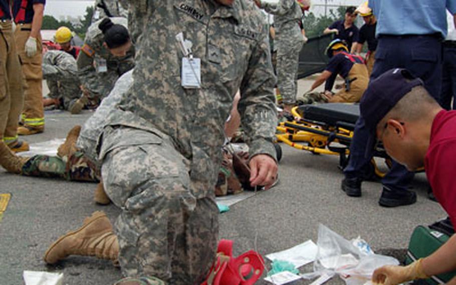 Pvt. William Conroy, 121st Combat Support Hospital, administers an IV during a mass casualty exercise at the Seoul American High School gym at Yongsan Garrison.