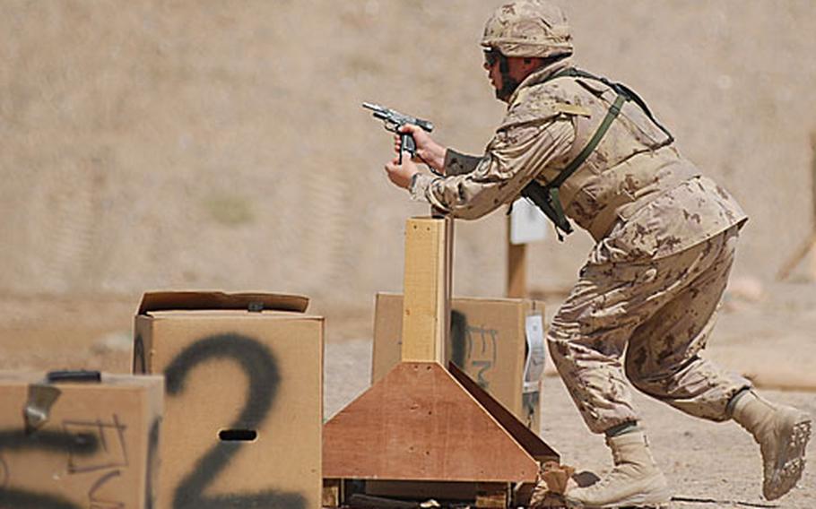 A Canadian Army soldier prepares to run from one target to another while ejecting a magazine from his 9 mm pistol. Shooters were required to move between a series of shooting positions during the competition.