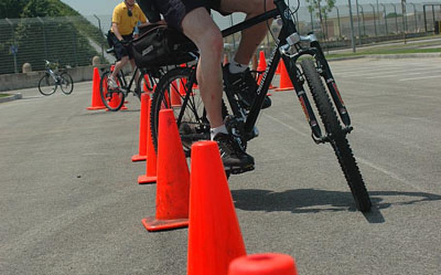 Petty Officer 2nd Class Russell Nyland, 22, maneuvers his police patrol bike through safety cones during training at the Naval Support Activity Naples, Italy, support site base.