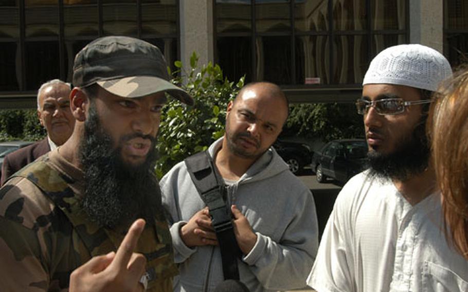 Abu Farooq, 22, left, speaks passionately about his perceived oppression in Britain outside London&#39;s Islamic Cultural Center. Farooq, and his comrade in white, Abu Samaha, 25, were two of the roughly two dozen young Muslim men who were excluded from the conference for what they say are their radical views.