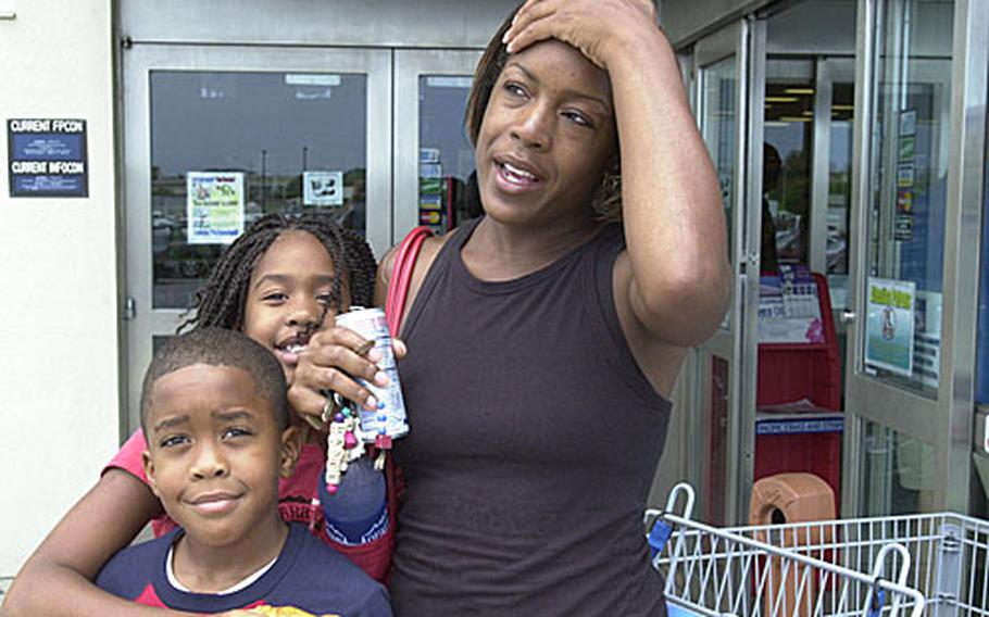 Tiffany White and her children, Tarayja, 9, center, and Jalan, 7, left, visit the Kadena Air Base commissary to stock up on water, snacks, candles and batteries in preparation for Typhoon Man-yi&#39;s arrival on Okinawa. Her mother was skeptical that the island might get a direct hit, but Tarayja said she still was excited about getting Friday off from a school program she attends.