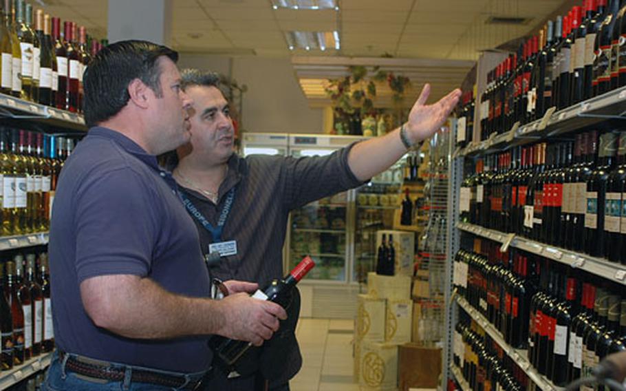 Supervisor Giuseppe "Pippo" Balsamo, right, discusses the wine sold in the wine and spirits section of his Navy Exchange at Naval Air Station Sigonella, Sicily.