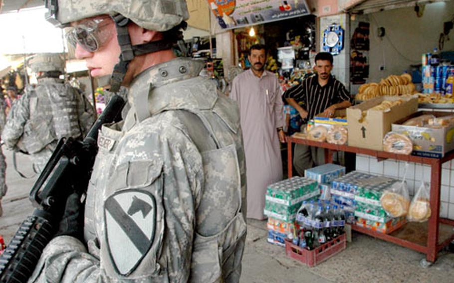 U.S. Army Sgt. Kurt Shroeder, 22, of Wisconsin Rapids, Wis., patrols a bustling marketplace in the town of al Qayyarah, roughly 190 miles north of Baghdad, as shopkeepers look on. His unit, the 5th Battalion, 82nd Field Artillery Unit, 4th Brigade, 1st Cavalry Division based in Fort Bliss, Texas, was conducting what has become a commonplace but dangerous foot patrol.