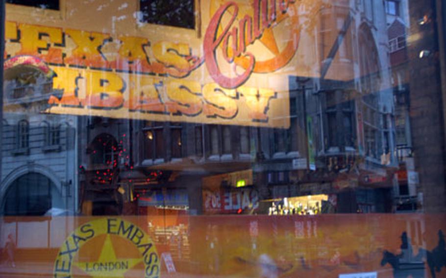 The buildings surrounding the Texas Embassy Cantina reflect off the glass front of the central London restaurant. The cantina is located one block north of Trafalgar Square.