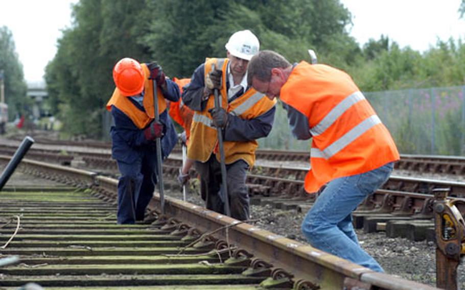 Volunteers shove a railroad track panel forward as part of a Mid-Norfolk Railway Preservation Trust project in Dereham on a recent Saturday afternoon.