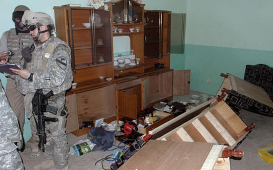 Second Lt. Seth Enterline inspects the living room in a house belonging to an Iraqi civilian after U.S. special operations and Iraqi forces raided it and two other nearby houses. Enterline talked to members of the household and the neighborhood sheikh, who helped to mediate the situation.
