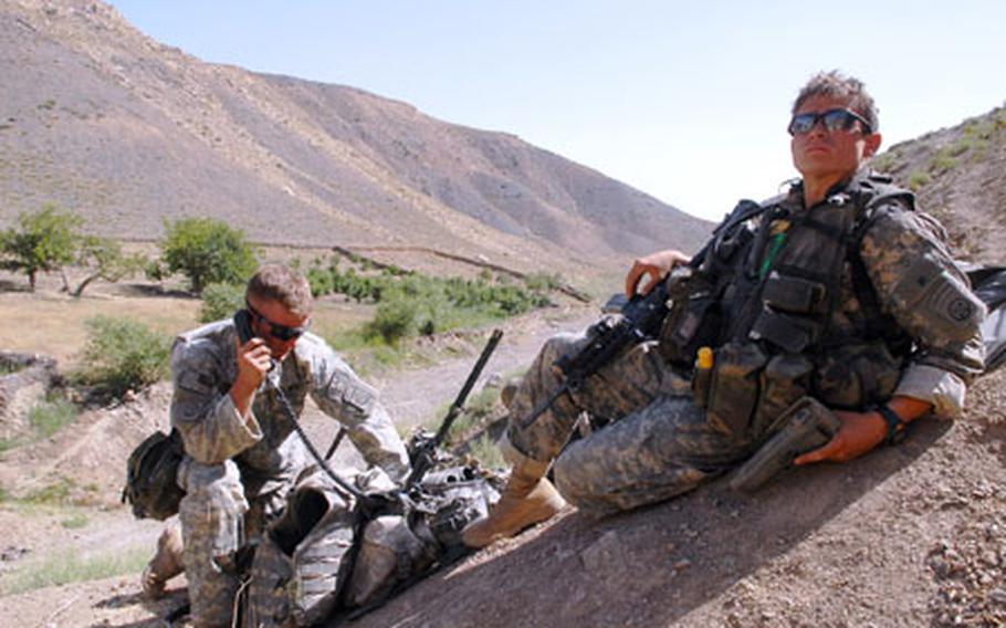 Sgt. Shane Nunes, 23, of Stockton, Calif., left, asks his command for permission to destroy an old Mujahideen tunnel in the remote mountains of Zabul Province, Afghanistan, recently as medic and Spc. Evan Derveloy, 26, of New Orleans, looks on.