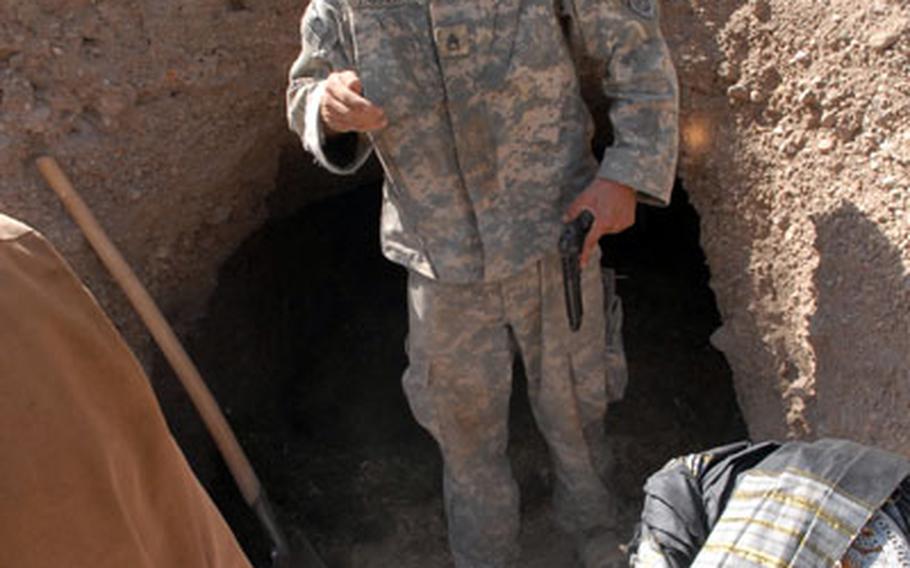 Staff Sgt. Joseph Moser, 23, of Highland, Ind., questions locals about a system of caves beneath their village in the mountains of Zabul Province, Afghanistan, recently.