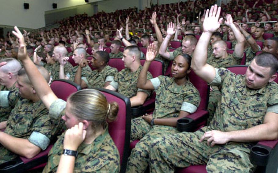 More than half the Marines at the Camp Foster Theater raise their hands Tuesday when Sgt. Maj. of the Marine Corps Carlton W. Kent asks who has tattoos.