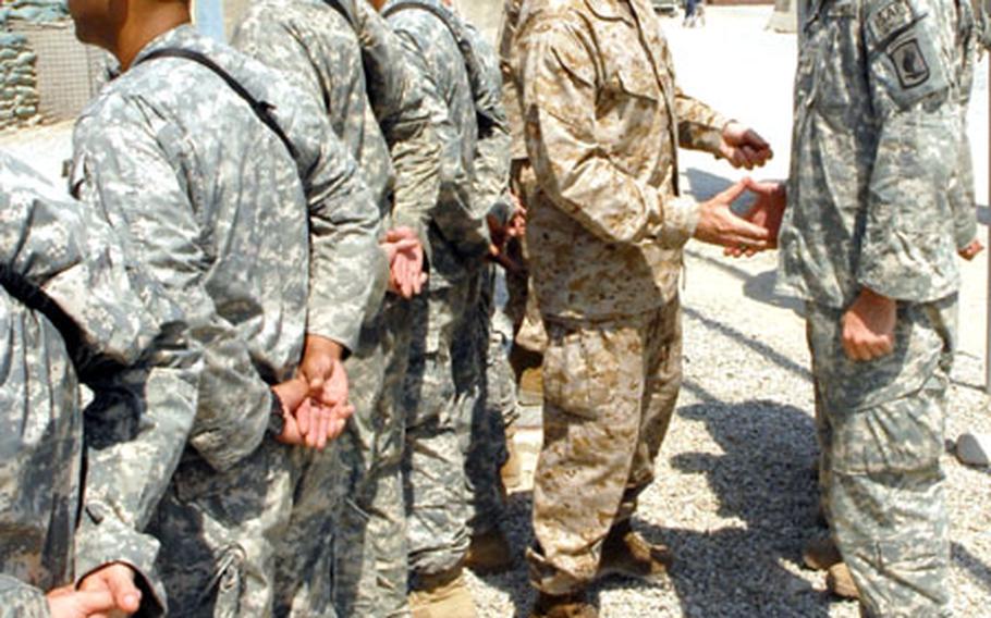Marine Gen. Peter Pace, chairman of the Joint Chiefs of Staff, hands out coins to 173rd Airborne soldiers in Afghanistan.