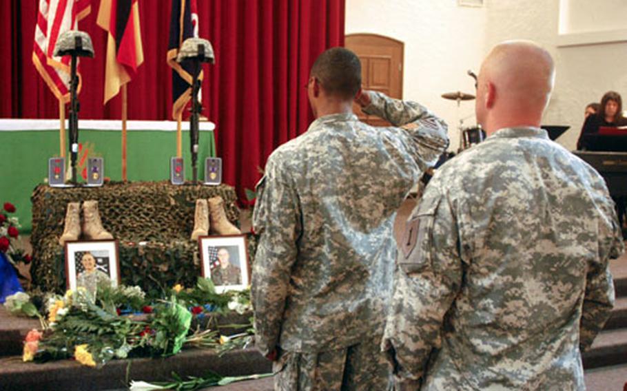 A soldier salutes a memorial display for Sgt. 1st Class Raymond R. Buchan and Staff Sgt. Michael L. Ruoff Jr. during a service Thursday at Ledward Chapel in Schweinfurt, Germany.