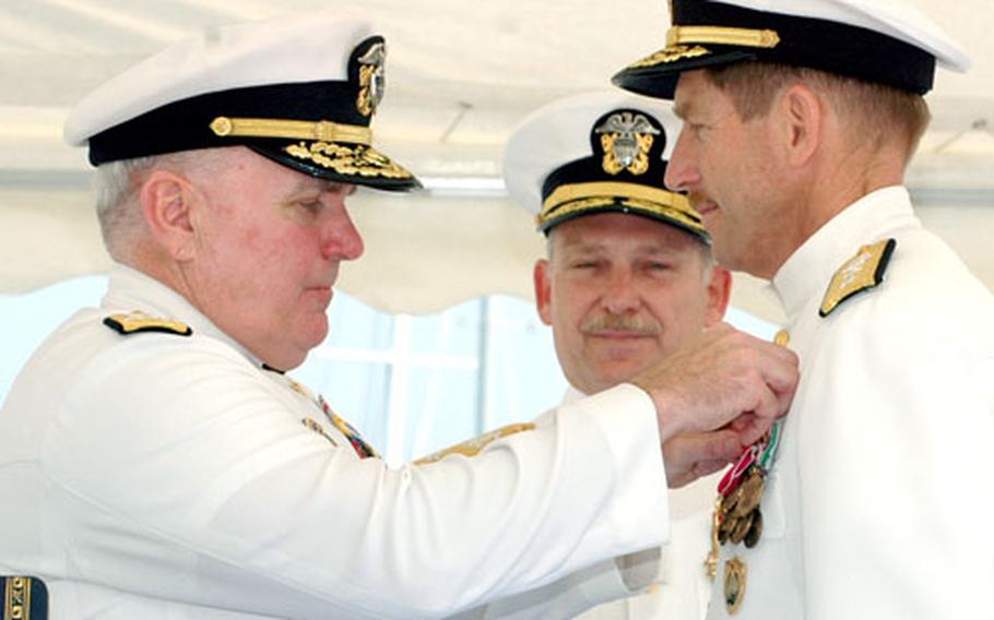 Vice Adm. Robert Conway Jr., commander of Navy Installations Command, pins the Legion of Merit medal on Rear Adm. Noel Preston, who Thursday relinquished command of Navy Region Europe and Maritime Air Naples. Rear Adm. Michael Groothousen, center, assumed command from Preston.