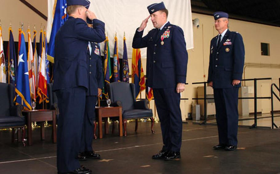 (From left) Lt. Gen. Bruce A. Wright, Col. Scott P. Goodwin and Col. John Newell III perform the change of command ceremony in front of local Japanese officials, airmen and their families. Airmen from the 374th Airlift Wing Command were gathered to participate in the change of command.