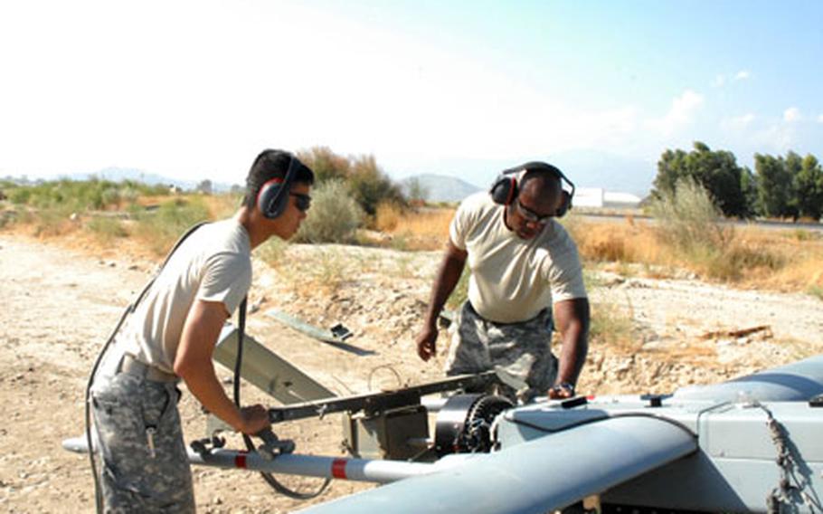 Sgt. Anh Huynh (left), 29, from Philadelphia, and Staff Sgt. Alton Jefferson, 29, from Gordon Heights, N.Y., both of Company B, 173rd Airborne Brigade Combat Team Special Troops Battalion, man the starter for a Shadow unmanned aerial vehicle prior to a launch Tuesday at Jalalabad Air Field, Afghanistan.