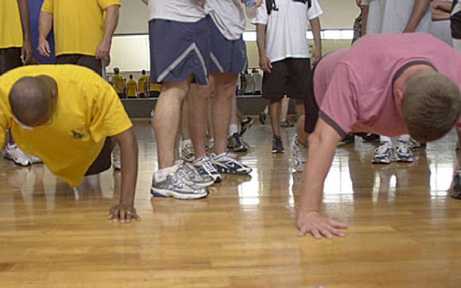 Tech. Sgt. Shaun Harris, left, and John Gouldthorpe attempt to do more push-ups than the other other during the Battle of the Services Fitness Challenge at Risner Gym on Kadena Air Base.