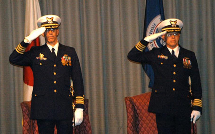 Capt. Michael L. Blair (left), the outgoing commander of the U.S. Coast Guard Activities Far East, and Capt. Gerald M. Swanson, the new FEACT commander, render a salute during a change of command ceremony.