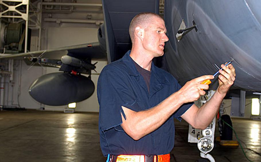 Airman 1st Class Brandon Ceccardi, an F-15C crew chief from the 67th Fighter Squadron at Kadena Air Base, Japan, performs a pre-flight check on an F-15 at Misawa Air Base, Japan.