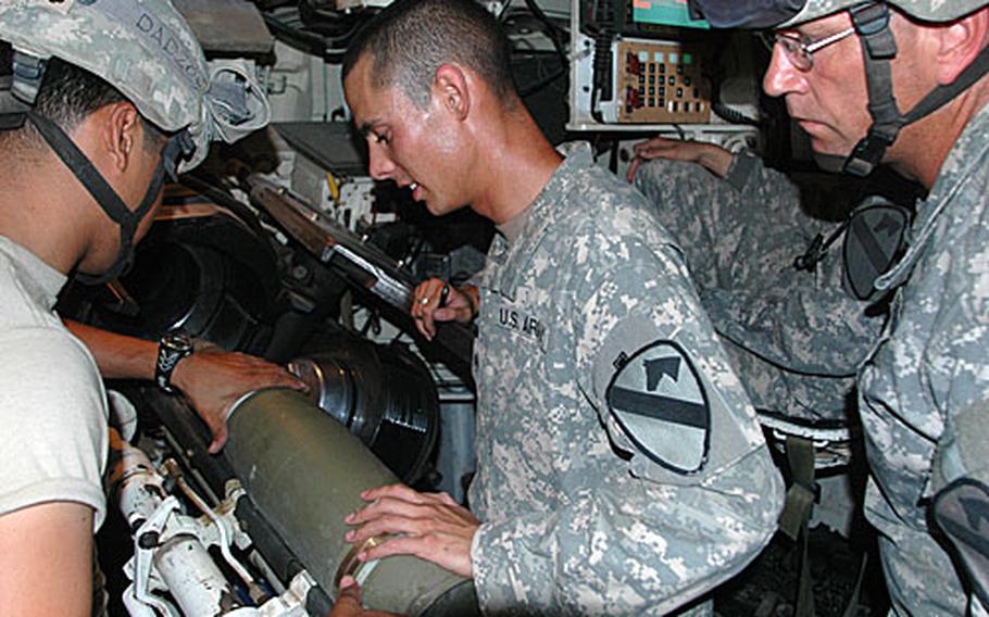 Spc. Miguel Diaz, 24, of Bayamon, Puerto Rico; Sgt. Nicholas Grant, 22, of Albuquerque, and Sgt. 1st Class Lea Masters, 43, of Chesapeake, W. Va., (left to right) work within the tight confines of a 155 mm Paladin howitzer.