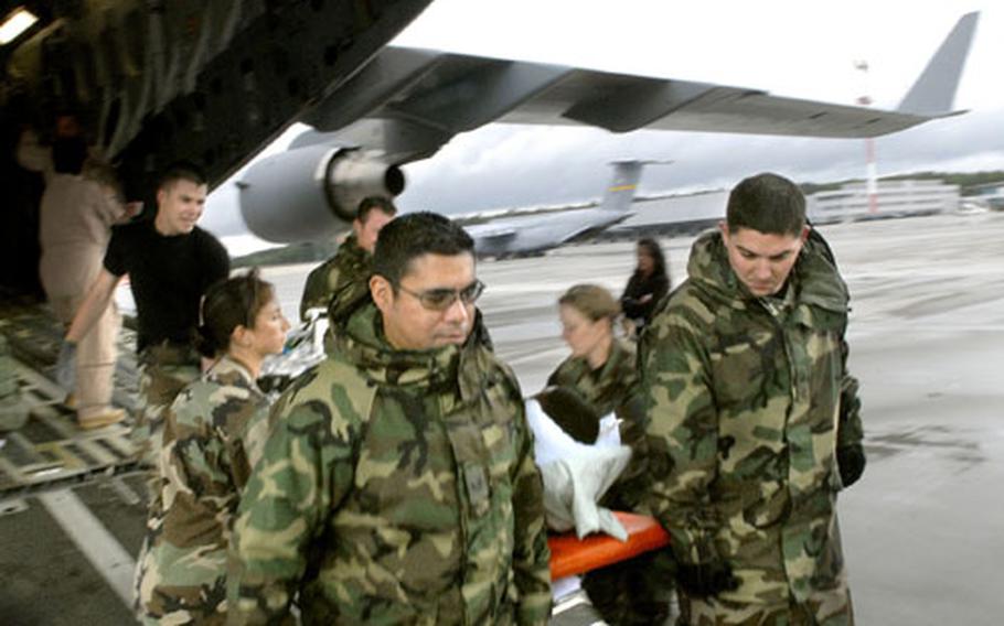 Staff Sgt. James Maher (left) and Senior Airman Felix Villareal, medics from the 435th Contingency Aeromedical Staging Facility, transport a patient from a C-17 coming from Iraq onto Ramstein Air Base in Germany on July 5.