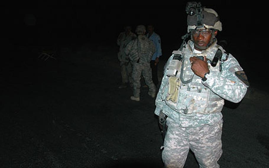 Sgt. Marvin Embry, 33, calls in a status check at an Iraqi checkpoint after members from his unit stopped briefly while on an anti-roadside bomb patrol. Embry and the other soldiers are with the 5th Battalion, 82nd Field Artillery Regiment, 1st Cavalary Division.
