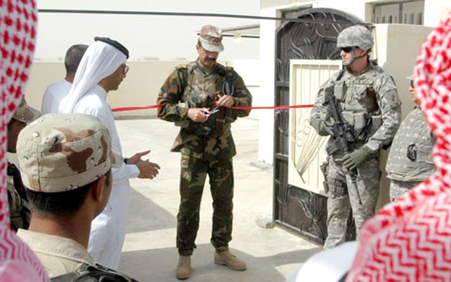 Iraqi Army Lt. Col. Raad Niif Haroosh cuts the ribbon during the opening ceremony for the new well. To his right is U.S. Army civil affairs reservist Staff Sgt. Larry Slough, 45, a native of Seattle, Wash., of the 431st Civil Affairs Battalion.