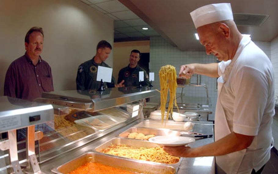 Raffaele Sansone, 52, serves up a plate of pasta Wednesday at the "Ciao Hall" dining facility at the Capodichino base in Naples, Italy. The facility is slated to close on Sept. 28, a move that means roughly 50 Italian contractors could be out of a job, including Sansone, who has worked there for 18 years.