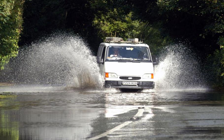 A van drives through a foot of standing water near the flooded town of Fairford on Tuesday.
