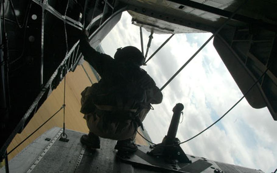 Staff Sgt. Will Eaton, 30, of Santa Rosa, Calif., a gunner with the 352nd Special Operations Group, hangs on to the interior of a MH-53 Pave Low helicopter during a manuever Wednesday afternoon while the chopper was en route to the Imperial War Museum in Duxford, England. The museum is hosting an Air Show Saturday to celebrate the 60th birthday of the U.S. Air Force.