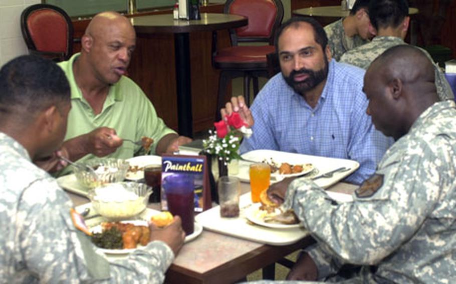Former All-Pro Baltimore Colts running back Lydell Mitchell, second from left, and Pittsburgh Steelers Hall of Famer Franco Harris, third from left, talk with Sgt. 1st Class Duane Pack, right, and Staff Sgt. Roosevelt Larry at Camp Red Cloud, South Korea, on Thursday.