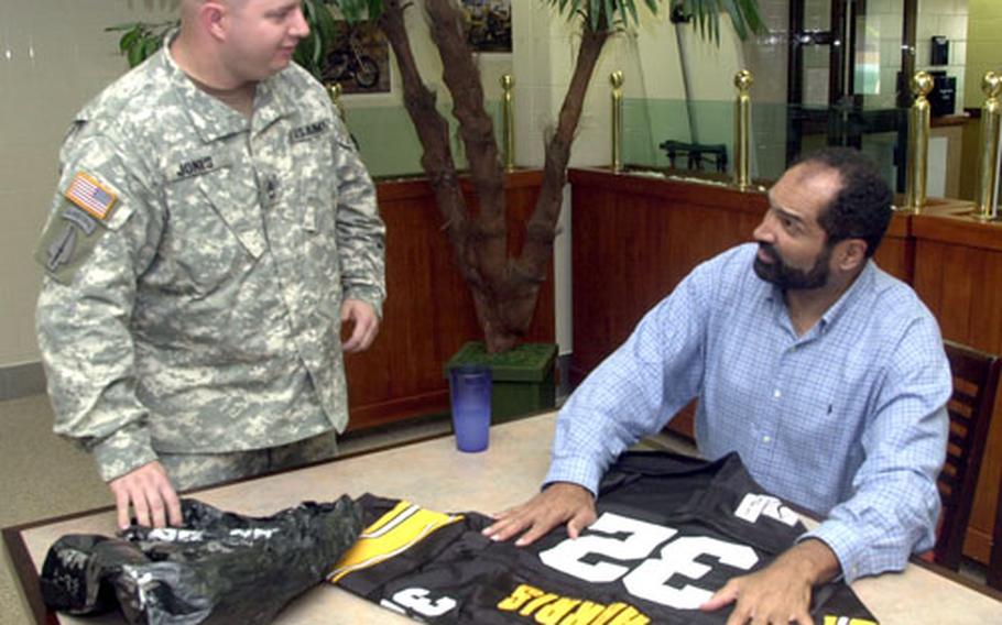 Franco Harris signs a jersey for Sgt. 1st Class Jeffrey Jones Thursday at Camp Red Cloud.