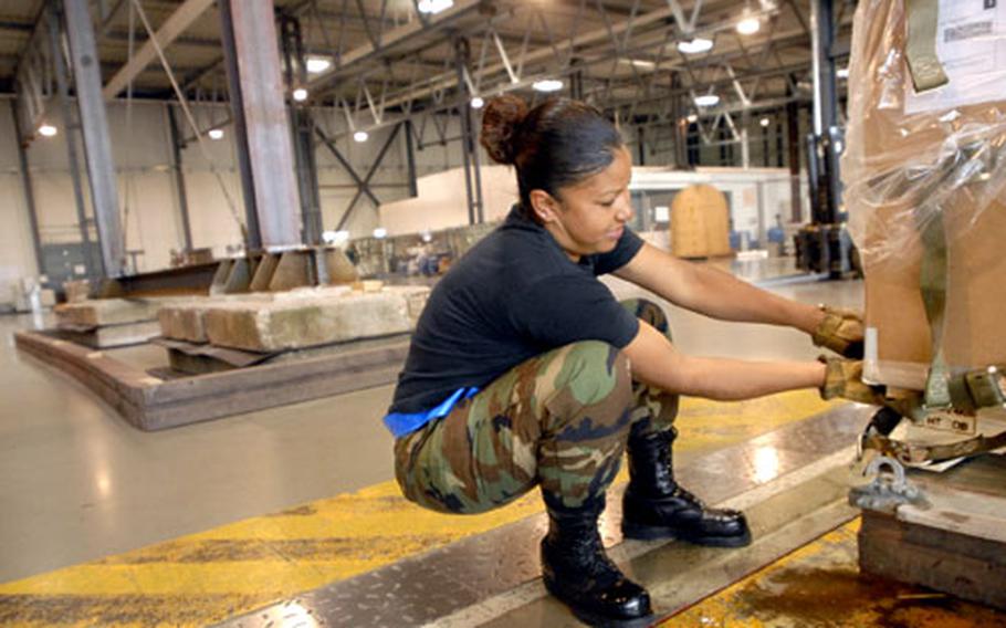 Senior Airman Andrea Butler, an aircraft transportation specialist from the 723rd Air Mobility Squadron, tightens straps on a pallet headed for Balad Air Base, Iraq, Thursday at the Ramstein air freight terminal.