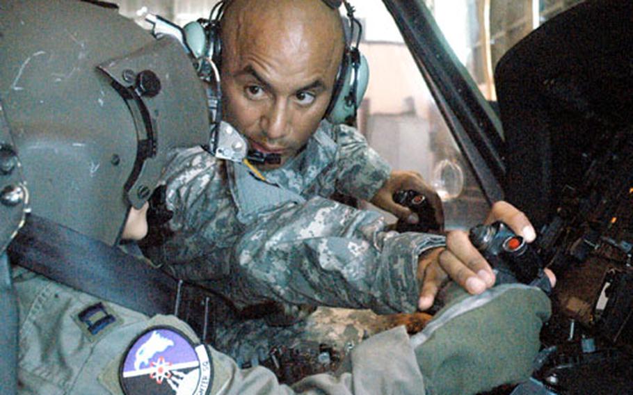 Army 2nd Lt. Jose Marquez shows Daniele Montico, 6, how to grip the controls of a Black Hawk helicopter parked Friday in a hangar at Aviano Air Base, Italy. Daniele, who has leukemia, was given a special tour of the base and got the opportunity to see Army and Air Force equipment and vehicles close up.