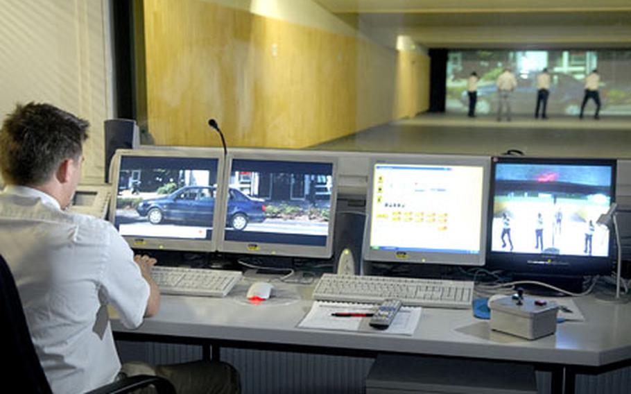 Tobias Schröter, the director of the new Pond Academy for Safety and Security, administers a shooting program in a control center overlooking the shooting range as site instructors shoot 9 mm handguns for proficiency in Erlensee, Germany. The shooting range gives shooters the ability to fire at computer interactive targets that score each shot.