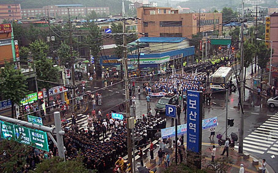 Demonstrators for and against U.S. forces’ presence in South Korea square off at the Bosan Station subway stop in Dongducheon. South Korean police surround the pro-U.S. Merchants Association of Dongducheon, bottom, while a group protesting the presence of U.S. forces in South Korea shouts slogans, top.