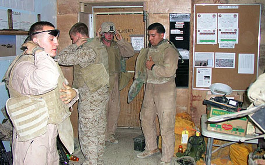 In western Anbar province, Marines at a patrol base in Rawah put on their helmets and body armor, known as PPE (personal protective equipment), before heading out on a patrol through part of the city.