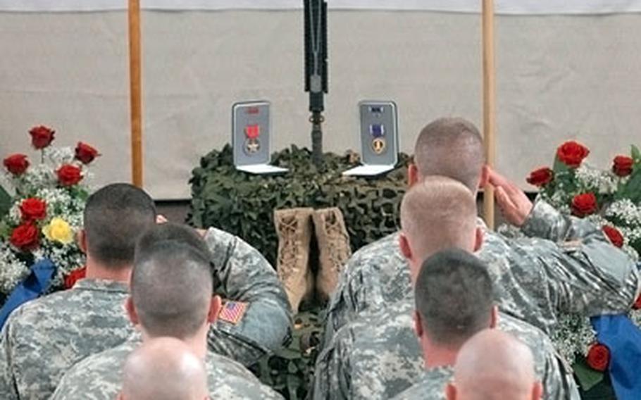 Soldiers give a final salute to Spc. Christopher Neiberger at the memorial ceremony at Ledward Barracks in Schweinfurt, Germany, for the 2nd Brigade Combat Team, 1st Infantry Division soldier killed in Iraq on Aug. 6, 2007.