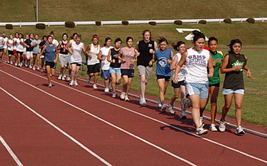 Thirty-two students from Camp Zama High School condition during women&#39;s volleyball team tryouts as the run laps around the track at Camp Zama, Japan on Tuesday. The women&#39;s volleyball coach, Dennis Decker, said 28 will make the team.