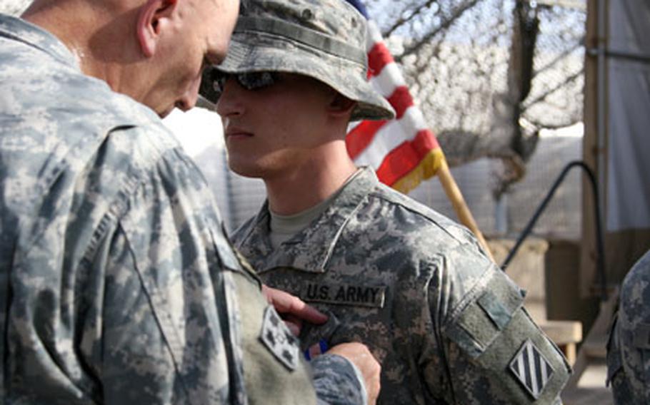 Lt. Gen. Raymond Ordierno pins the Soldier&#39;s Medal on Sgt. Christofer M. Kitto, 23, of Altamont, N.Y., during a ceremony Wednesday at Combat Outpost Cleary, south of Baghdad.