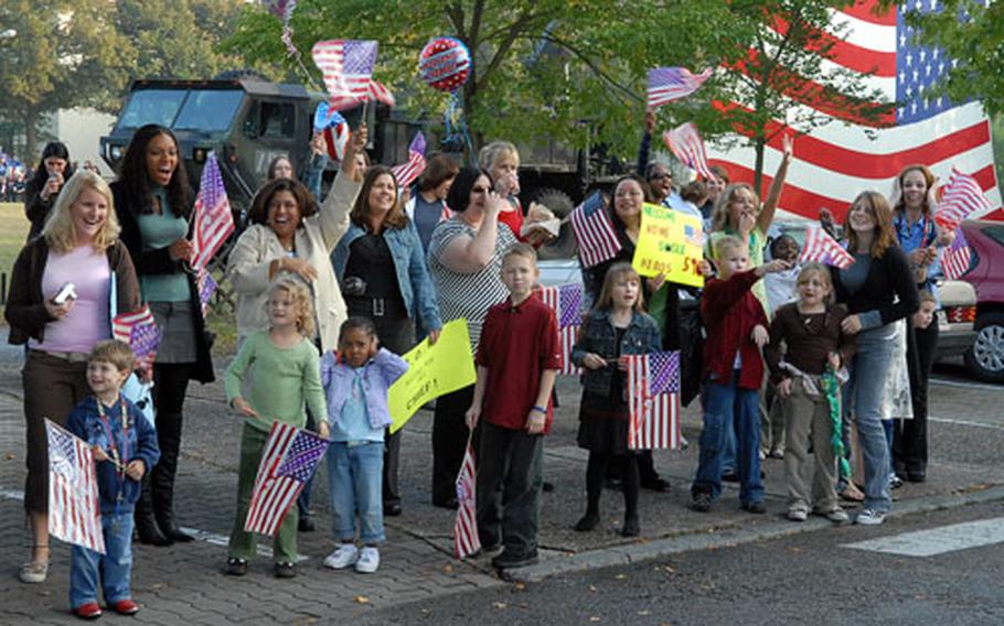 Family members and friends wave flags and cheer, as buses carrying about 200 soldiers of the 596th Maintenance Company arrive at Kelley Barracks in Darmstadt, Germany, on Thursday evening. The soldiers were returning from a deployment to Iraq.